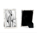 A silverplated bamboo photo frame with a 10cm x 15cm photo of flowers, displayed in portrait orientation, with a black flock backing, presented in a branded giftbox.