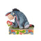 Eeyore Disney Traditions figurine by Jim Shore holding a red checkered heart, with intricate patterns on the base.