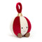 A plush bauble toy with alternating red and white segments, topped with a shiny gold accent and a red loop. It has a cute smiling face and small brown feet at the bottom.