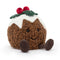 A cheerful Christmas pudding plush toy with textured brown body, white icing top, red berries, green leaves, and cute legs.
