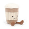 A plush toy resembling a coffee cup with a creamy top, mocha body, and ribbed texture that mimics a cup sleeve. It has a cheerful face with black eyes and a smile, and brown corded legs.