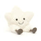 A plush white star toy with a cheerful face, beaming with two black eyes and a curved smile. The star sits upright, showing off its soft texture, and has cute, little gray corduroy feet.