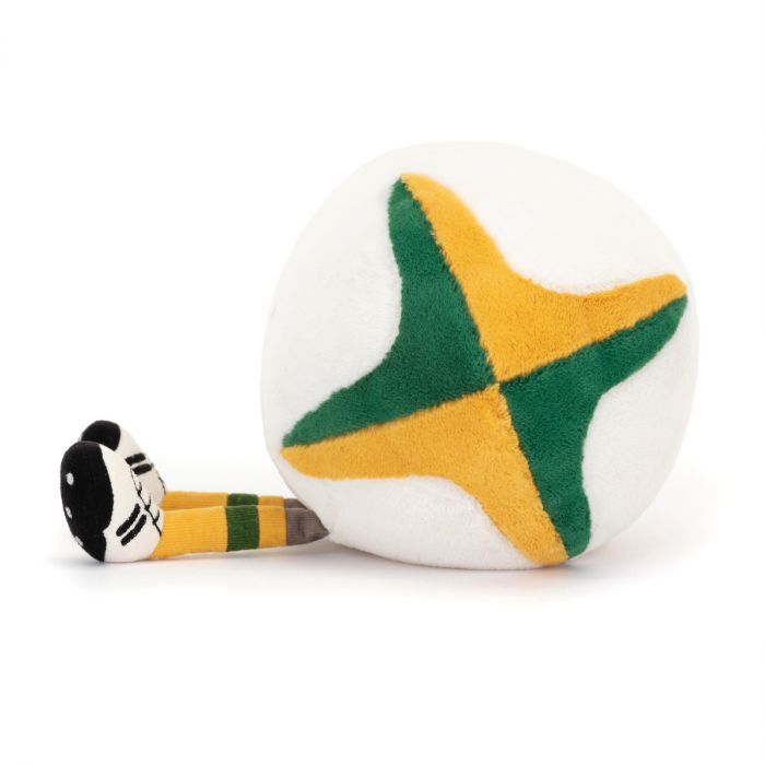 A plush toy resembling a round ball with a green and yellow star design on its white surface. Protruding from one side is a tiny leg with a black and white striped shoe and a yellow and green striped sock. The toy appears soft and cuddly.
