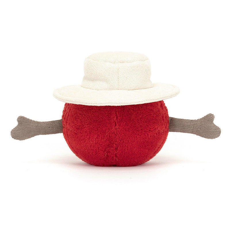 A red plush toy cricket ball with a white sunhat on top and two brown protruding arms on its sides.