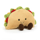 A colorful and vibrant Jellycat Amuseable Taco plush toy, featuring a tactile shell, soft suedey lettuce, tomato details, and cute cordy booties.