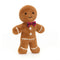A plush gingerbread man toy with a cheerful face, white icing details, three white buttons, and a red and purple tartan bow tie.