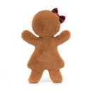 A gingerbread plush toy viewed from the back, displaying its fluffy brown texture. The toy has a tartan bow on its head and is in a standing posture with arms raised.