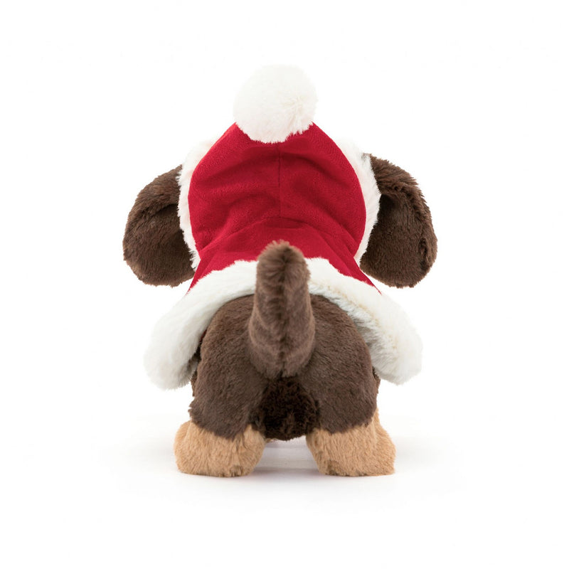 A rear view of a brown plush toy dog wearing a festive red cloak with white trim, showcasing its fluffy tail and hind legs.