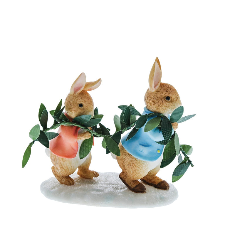 Photo from the side: Figurine of Peter Rabbit and Flopsy carrying the leaves